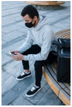 Young adult sitting down looking at his phone
